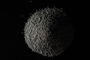 Image is of a pile of Conditioned Cut Wire blasting and peening media on a black backdrop.